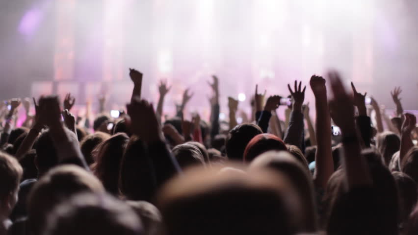 Crowd Partying At A Rock Concert. Silhouetted Hands And Flashing Lights