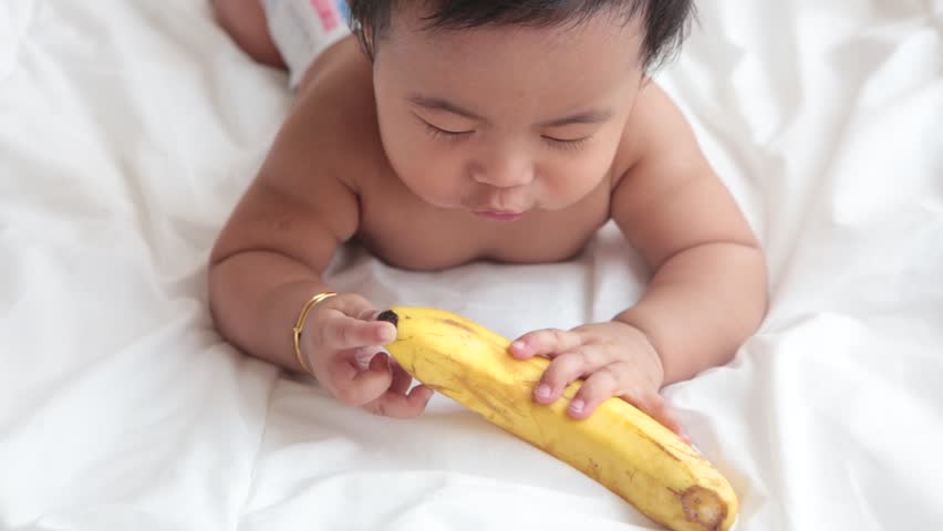Cute Little Asian Baby Girl Plays With Banana Stock Footage Video