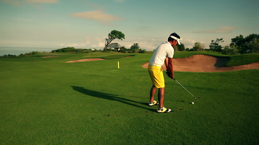 amazing golf course at dawn with a golfer teeing off