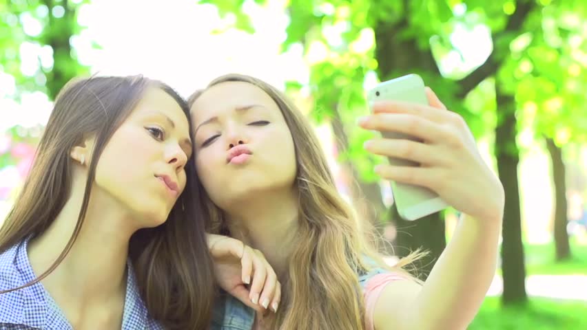 Outdoor Portrait Of Teen Friends Taking Photos With A Smartphone Two