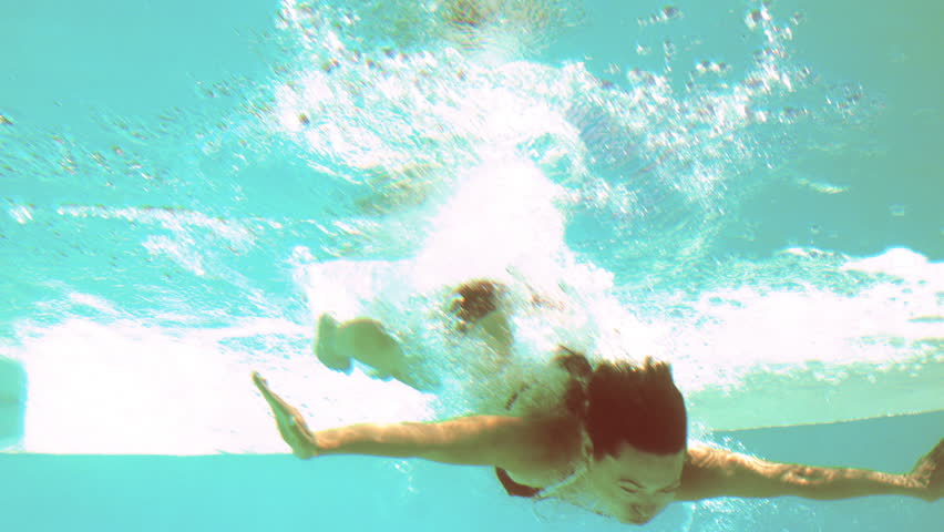 Brunette Diving Underwater In Swimming Pool In Slow Motion