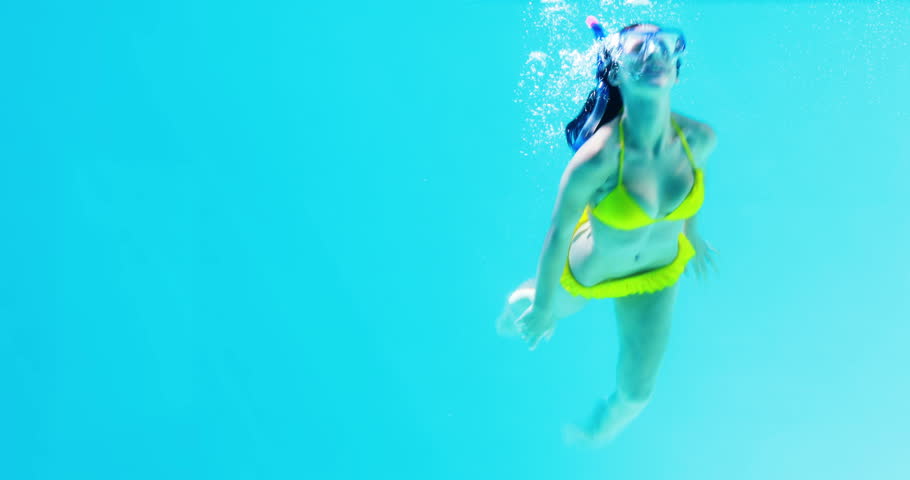 Pretty Brunette Swimming Underwater Into Pool With Snorkel On Her