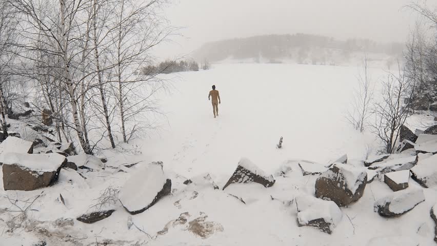 Naked Man Walks By Snow Covered Pond At Winter Day During Blizzard Aerial View Stock Footage