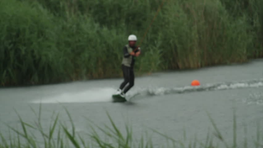 A Wakeboarder Rides Behind The Cable At A Park In The Rain In Slow