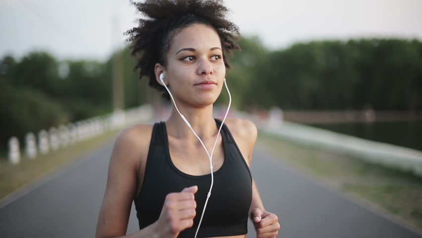 Woman Running At Sunrise Listening To Music With Earphones Stock ...