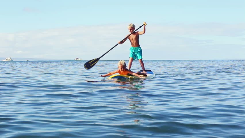 Stand Up Paddling In Hawaii. Young Blonde Boy Jumps Of Surfboard Into ...