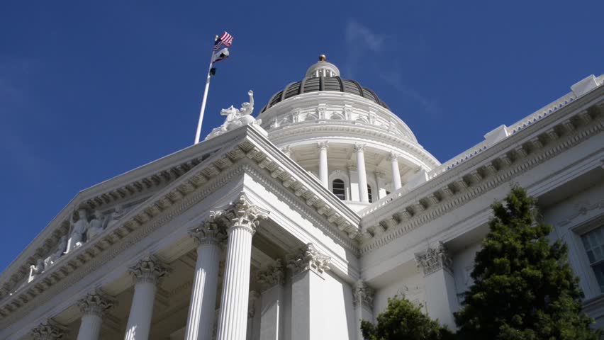 California State Capitol Building In Sacramento With Blue Sky And Flags ...