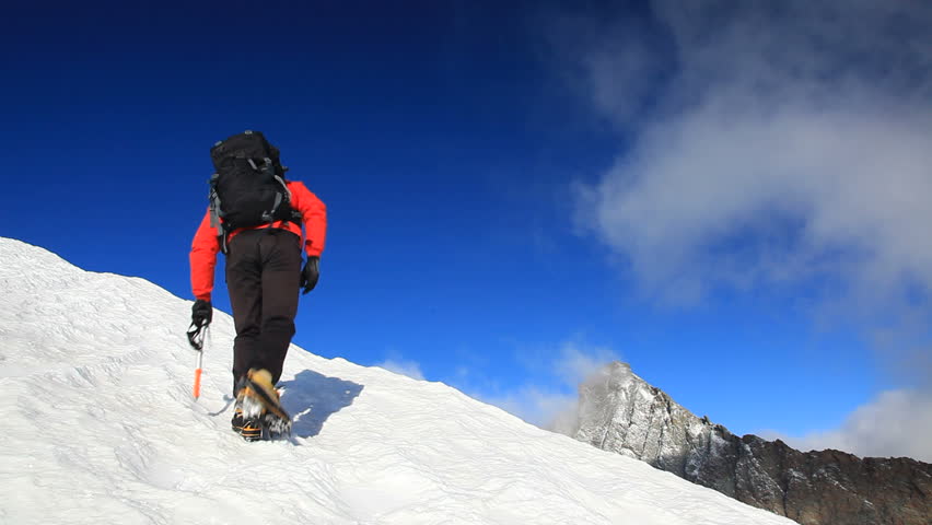 Mountaineer Walking Uphill Along A Snowy Slope. Rear View. Western Alps ...