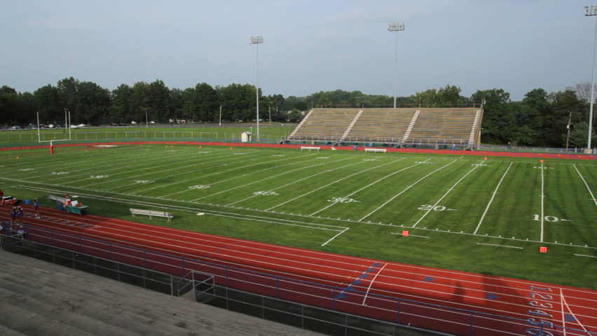 Moving Along A Football Field And Empty Bleachers. Shot With A ...