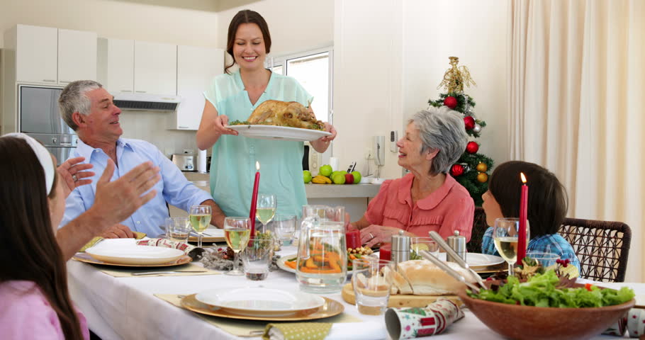 Mother Bringing Turkey To Dinner Table At Christmas At Home In The ...